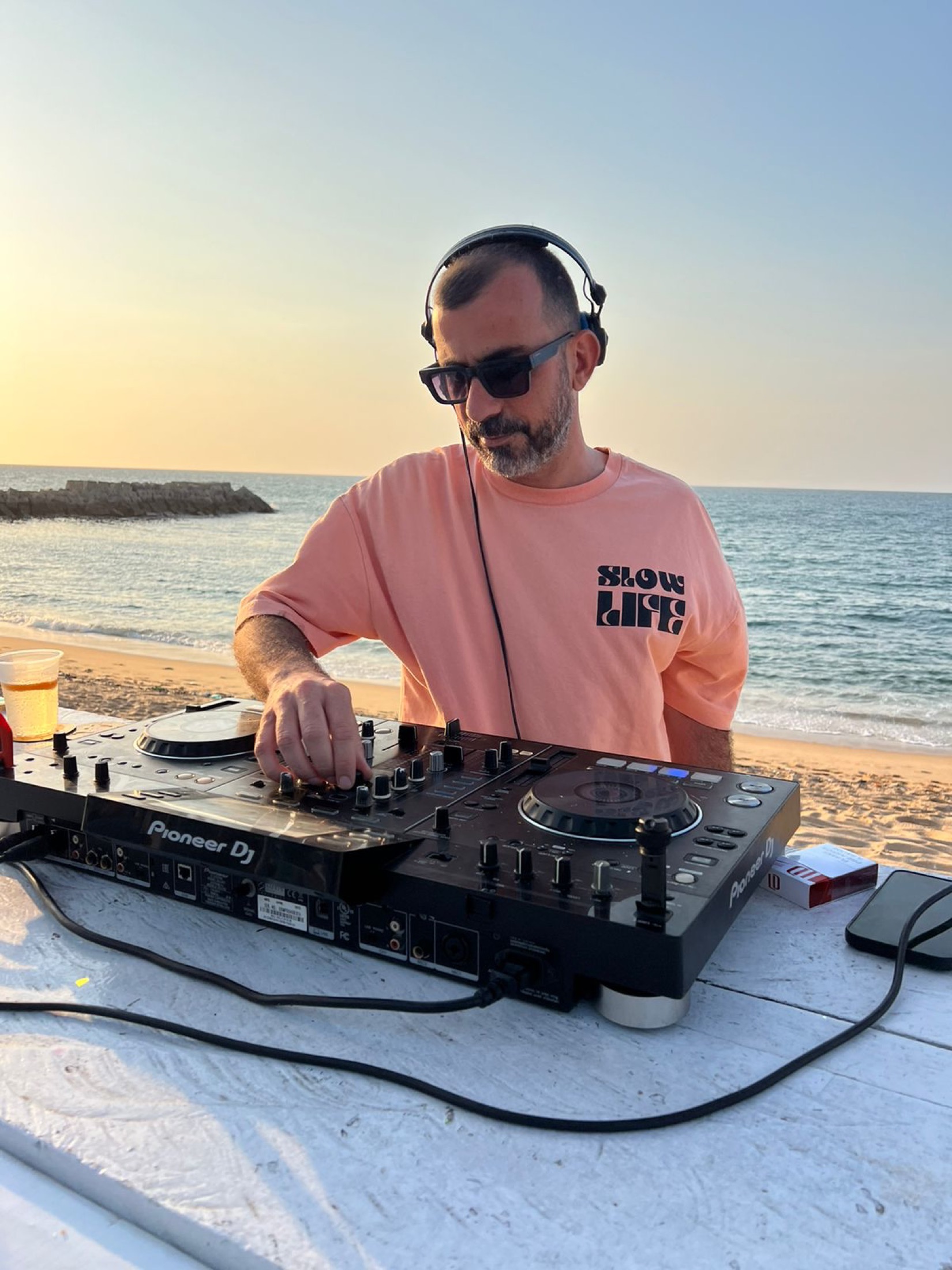 KULAS performing outdoors at sunset by the sea.